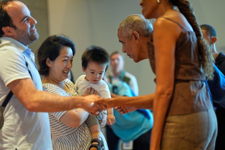 Barack and Michelle Obama surprise first visitors to newly opened presidential center