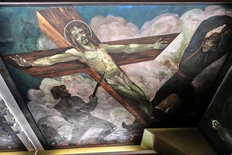 Inside a historic church painted with murals that reflect searing social commentary