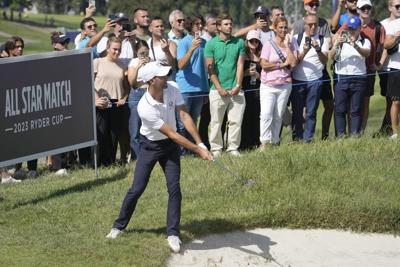 Novak Djokovic takes his tennis racket onto the 1st tee of golf's Ryder Cup All-Star match