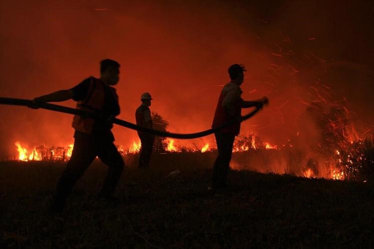 Firefighters are trying to put out a peatland fire threatening homes on Indonesia’s Sumatra Island