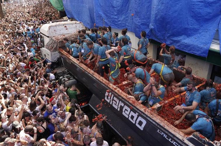 Revelers hurl tomatoes at each other and streets awash in red pulp in Spanish town's Tomatina party