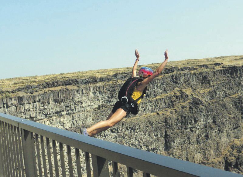 Base jumpers parachute from lofty Snake River bridge