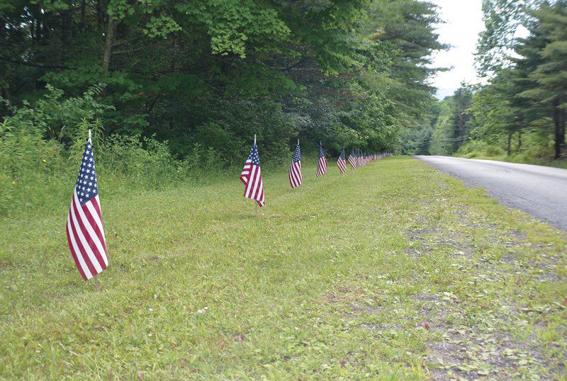 Man lines local road with grand old flags
