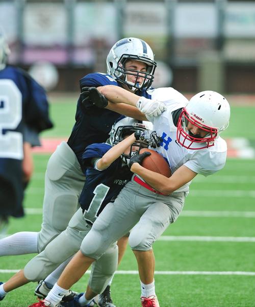 FOOTBALL: Heritage Middle School's Braden Cooper and WBMS's Logan Lawhorn and Navaar MacDonald-Risner