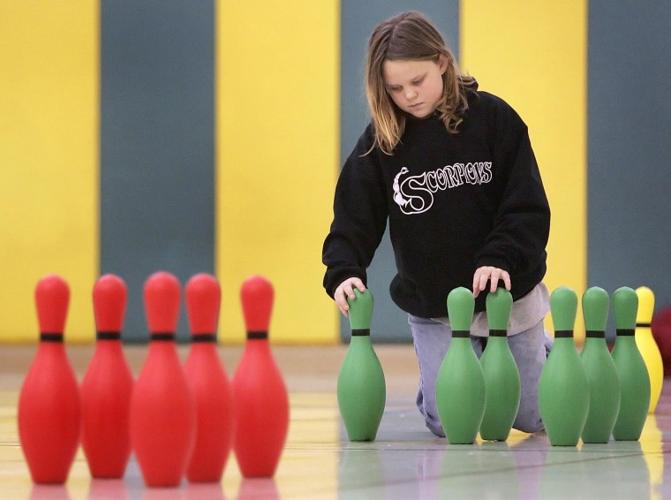 Kids knocking the pins down in P.E.