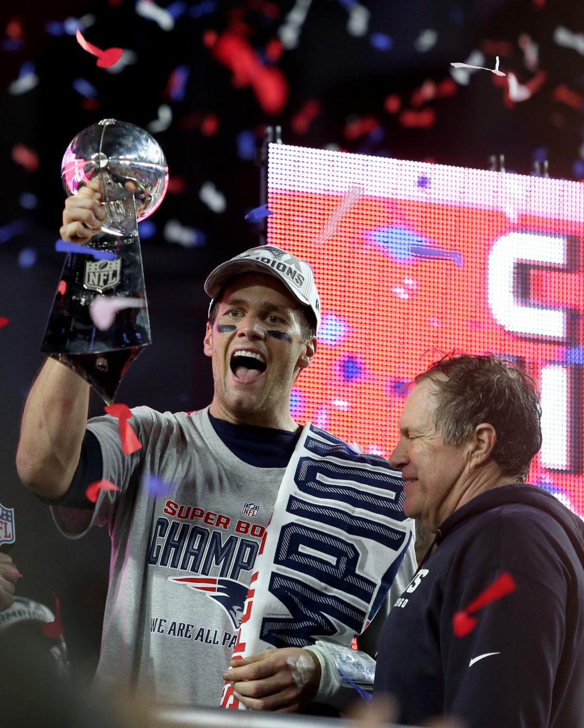New England Patriots quarterback Tom Brady and head coach Bill Belichick celebrate with the trophy after winning Super Bowl XLIX in Glendale, Ariz.