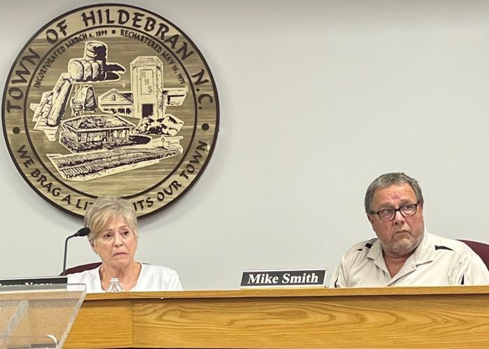 Hildebran council members Jody York and Mike Smith listen to public comments during Monday's meeting.
