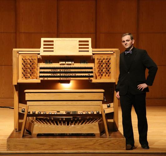 Joseph Franklin stands with the organ console at App State