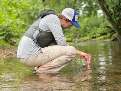 Grant Buckner of Catawba Riverkeeper samples the water in a creek.