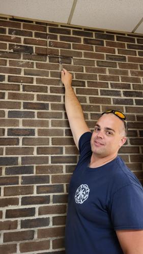 Fire Chief Truman Walton points to a section of wall jutting out