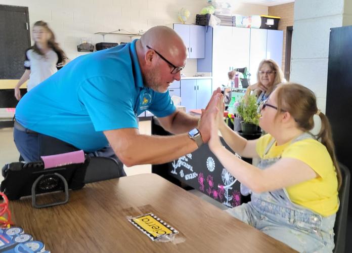 Mike Swan plays pat-a-cake with North Liberty School student