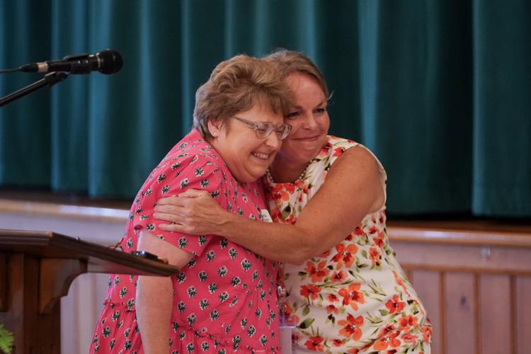 Governor's Volunteer Service Award winner Joyce Poteet, left, gets a big hug from Cyndi Akins of AMOREM Hospice and Palliative Care. Akins nominated Poteet for the award.