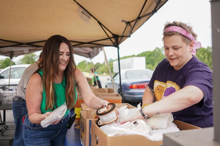 Burke United Christian Ministries staff members Joni Davidson, left, and volunteer coordinator Angela Smith pack food boxes at the ministry's new home on East Fleming Drive.