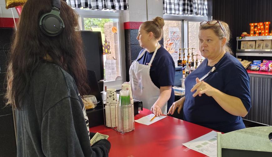 Cafeteria worker takes student's order at Claws Cafe
