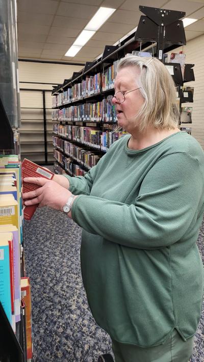 Circulation Services Supervisor Nicole Mull shelves a returned book