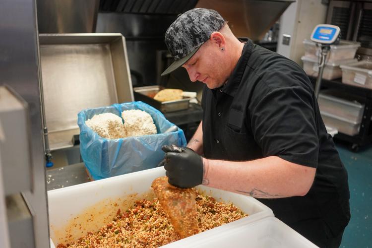 C2 Life staff member Travis Deal mixes jambalaya at the company's production facility in Valdese earlier this week. The food distribution company cooks healthy, nourishing meals to freeze, ship, and deliver to Medicaid recipients in 16 different N.C. co...