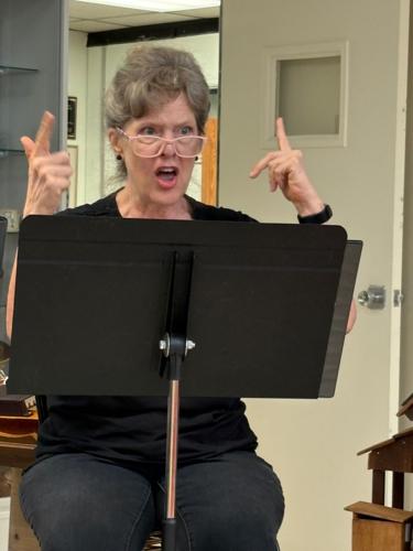 Dr. Kelly S. Taylor performs during the Burke Theater Guild's readers theater program Thursday.