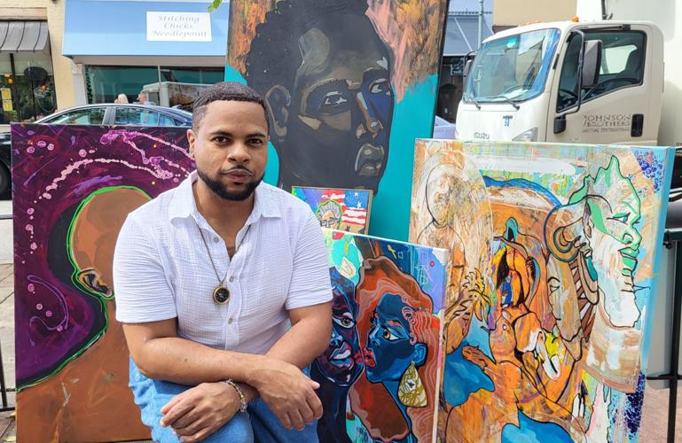 Jarvis Conley sits with some of his paintings