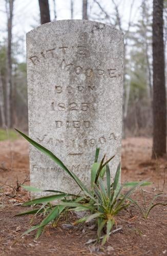 A yucca plant grows beside the gravestone of Rittie Moore at Rock Hill Cemetery. Families often set out perennials to help mark the graves of loved ones.