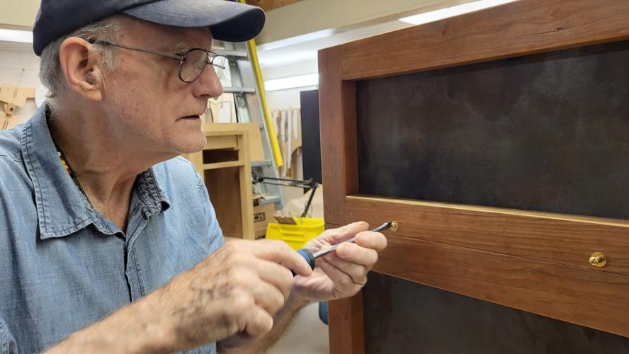 John Ferguson tightens a screw into the time capsule