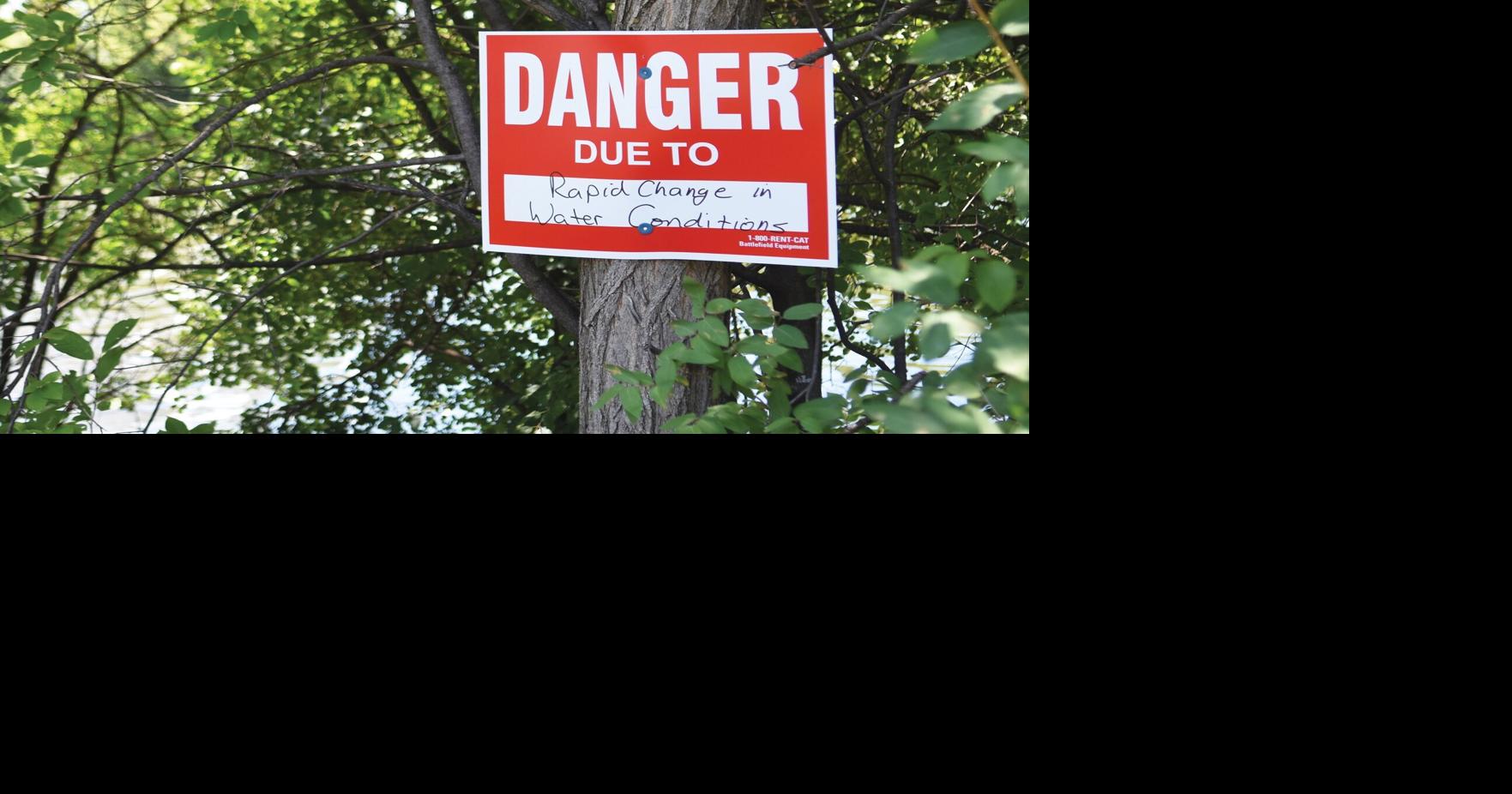 Signs posted by Hunter Street bridge warning of rising water levels