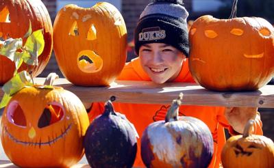A child poses for photos next to the Pumpkin sculptures by