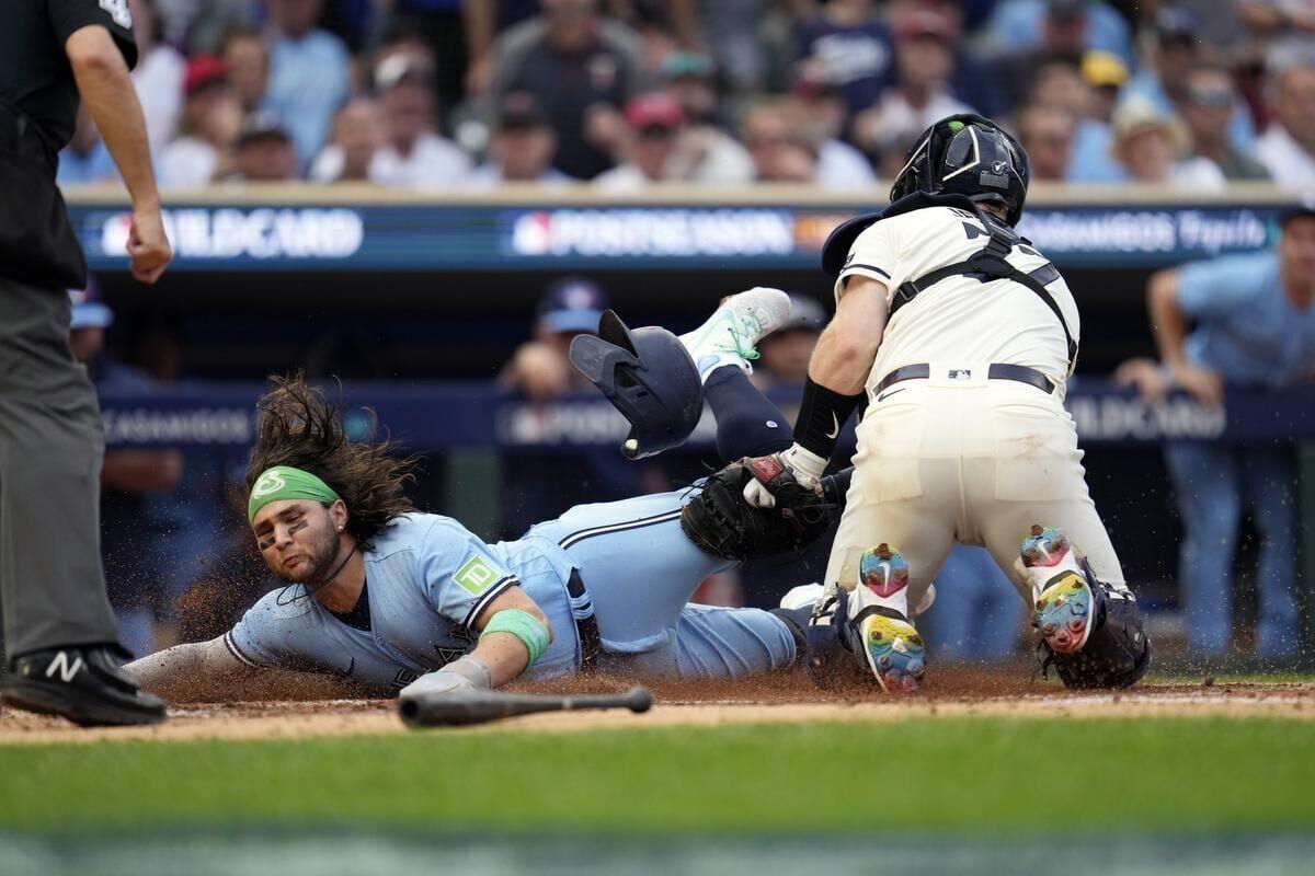 Toronto Blue Jays shortstop Bo Bichette, left, catches a ball at