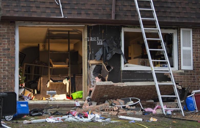 Debris, bricks and overturned chairs litter yard after house explosion