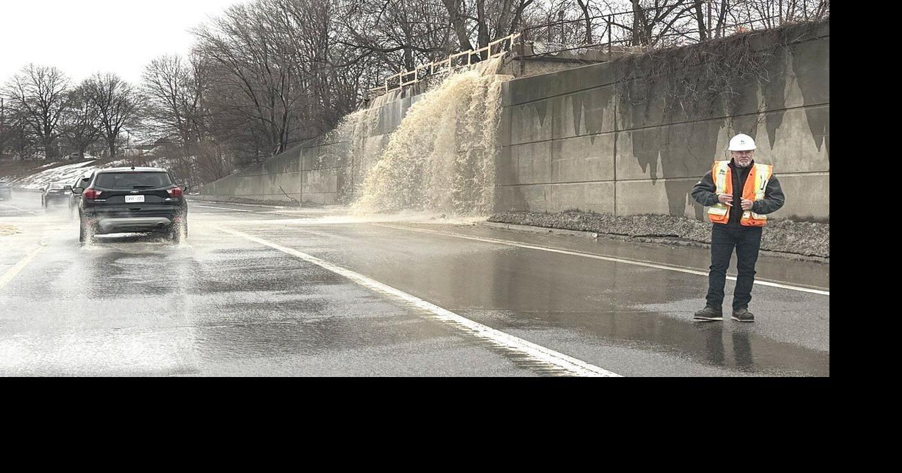 Water pours over the retaining wall at the Frederick Street Bridge demolition site on Highway 85, causing one-lane traffic.