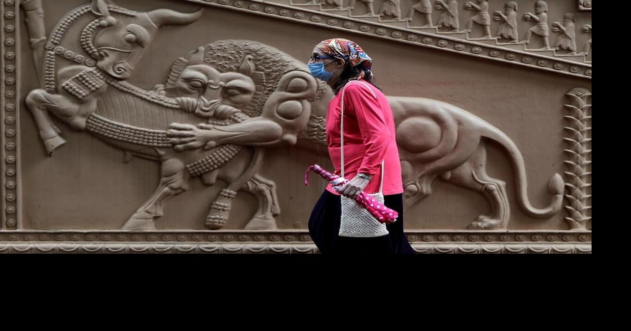 A pedestrians, wearing a protective face mask, walks past Louis Vuitton  store in downtown Rome, Italy