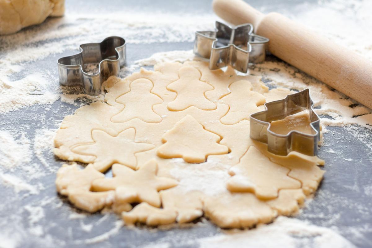 Making homemade Christmas cookies.The dough and shape on a dark background