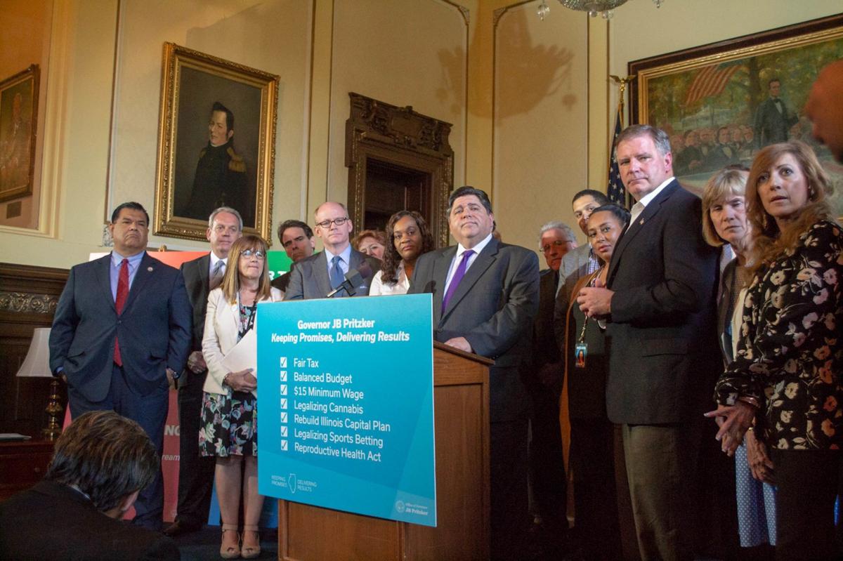 Illinois Gov. J.B. Pritzker stands among a bipartisan group of senators