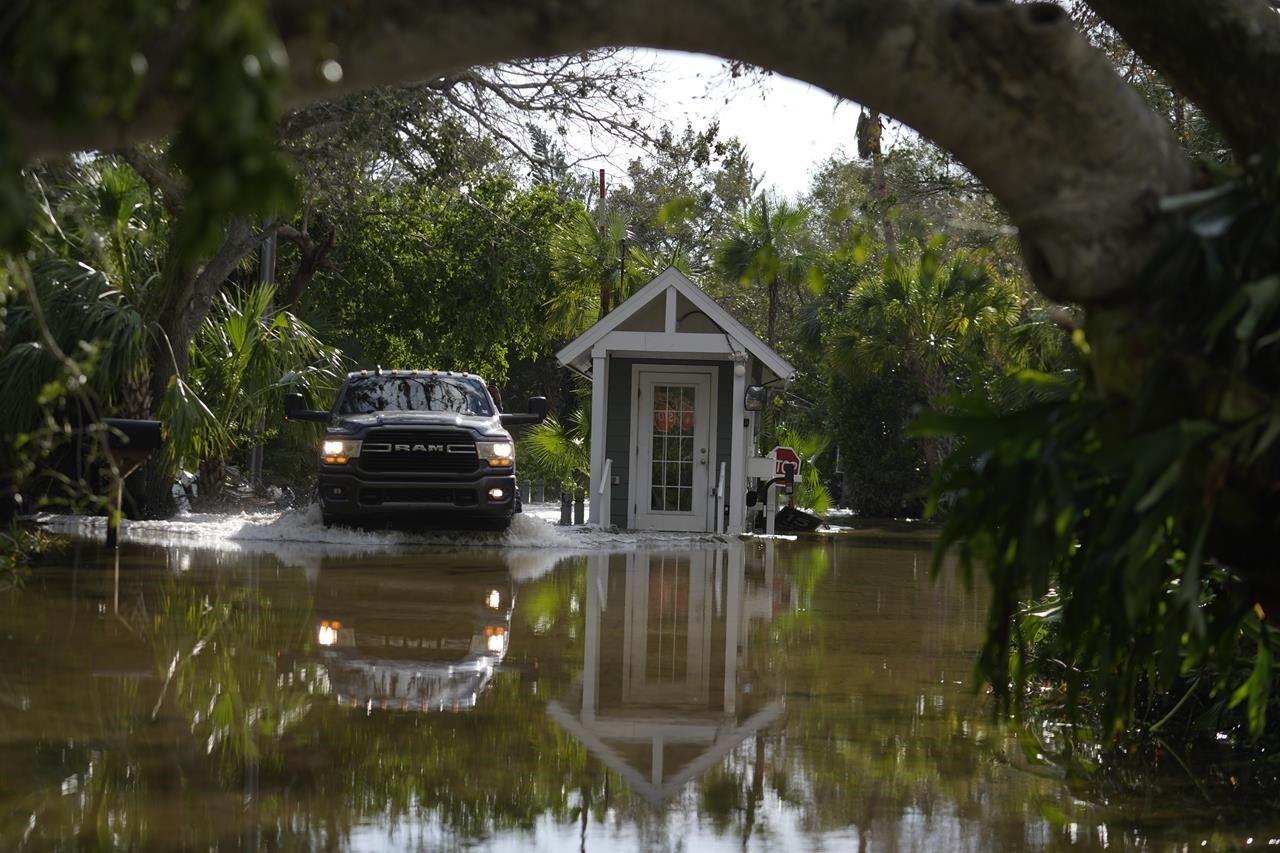 Residents Slog Through Flooded Streets, Pick Up Debris After Hurricane ...