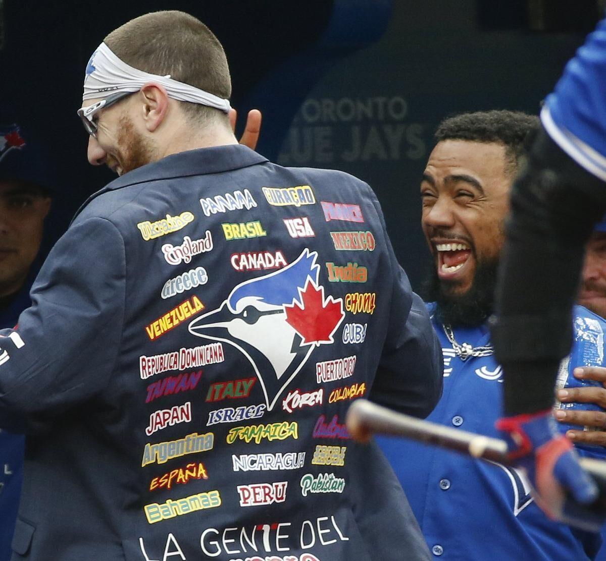 A fan wearing a Toronto Blue Jays jersey holds a sign for