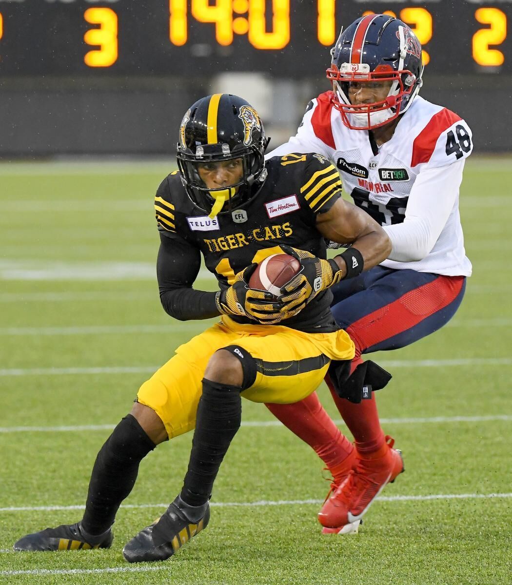 Hamilton Tiger-Cats defensive back Javien Elliott hands the ball