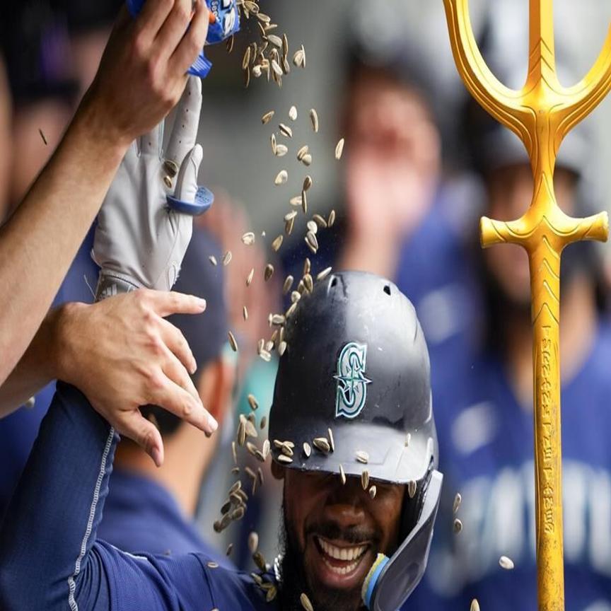 Seattle Mariners' Teoscar Hernandez holds a trident in the dugout