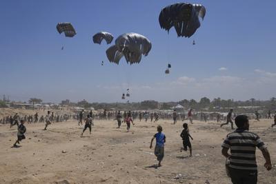 Photos show Palestinians pursuing food aid after the latest air drops in Gaza