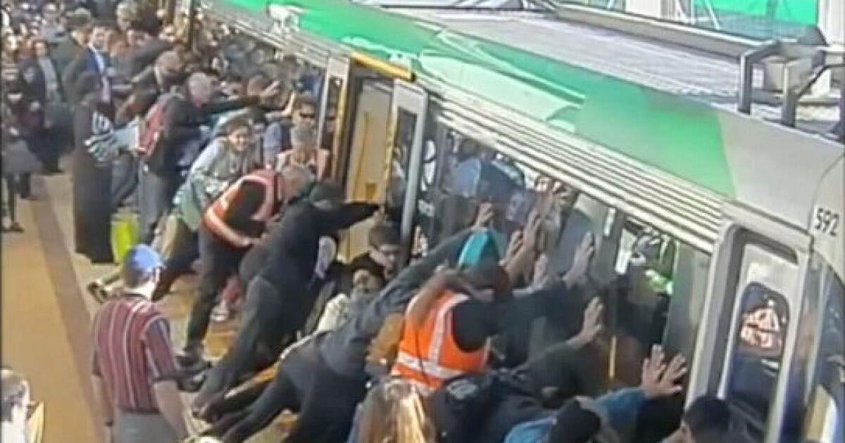 Australian commuters tip train cars to rescue trapped man