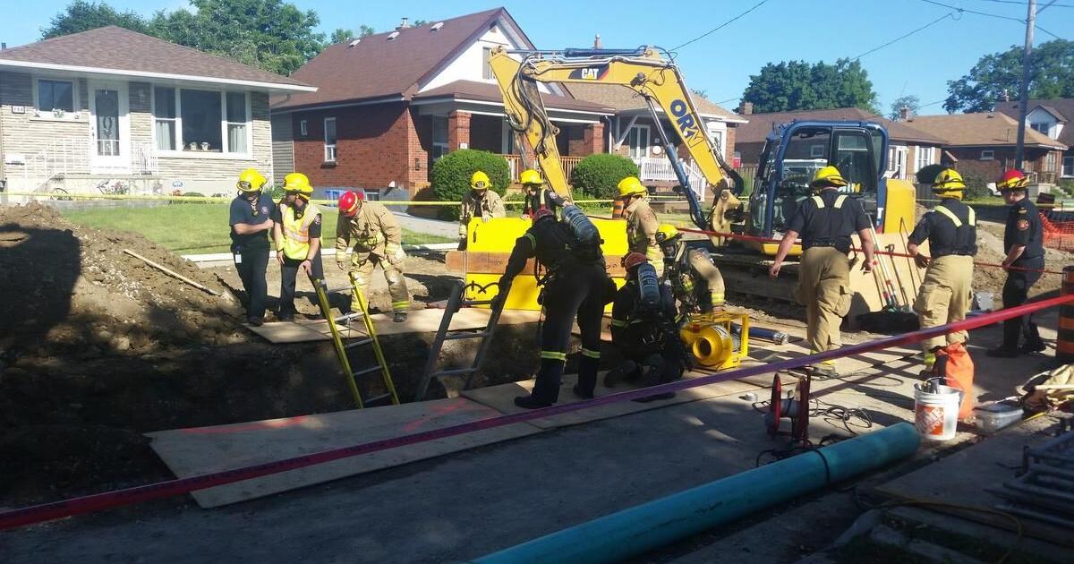 Crews rescue construction worker trapped in trench under backhoe in Oshawa