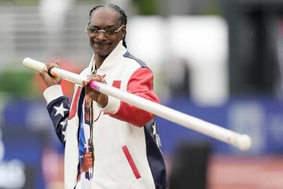 Snoop Dogg carries the Olympic torch before opening ceremony in Paris