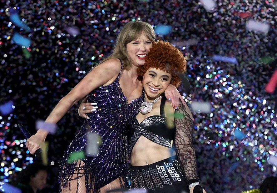 Taylor Swift smiles and hugs a grinning Ice Spice on stage while confetti rains down on them.