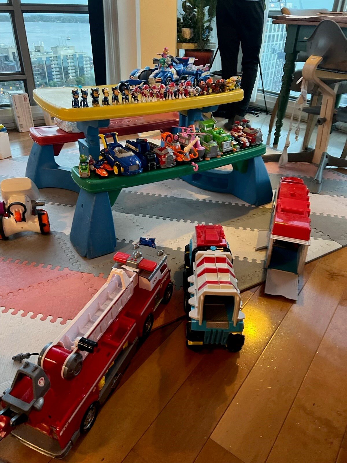 Toys set out on a table and on the floor of a condo
