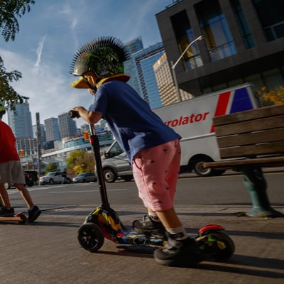 A photo of a young boy riding a scooter
