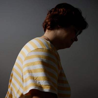 A photo of a girl wearing a yellow and white striped T-shirt