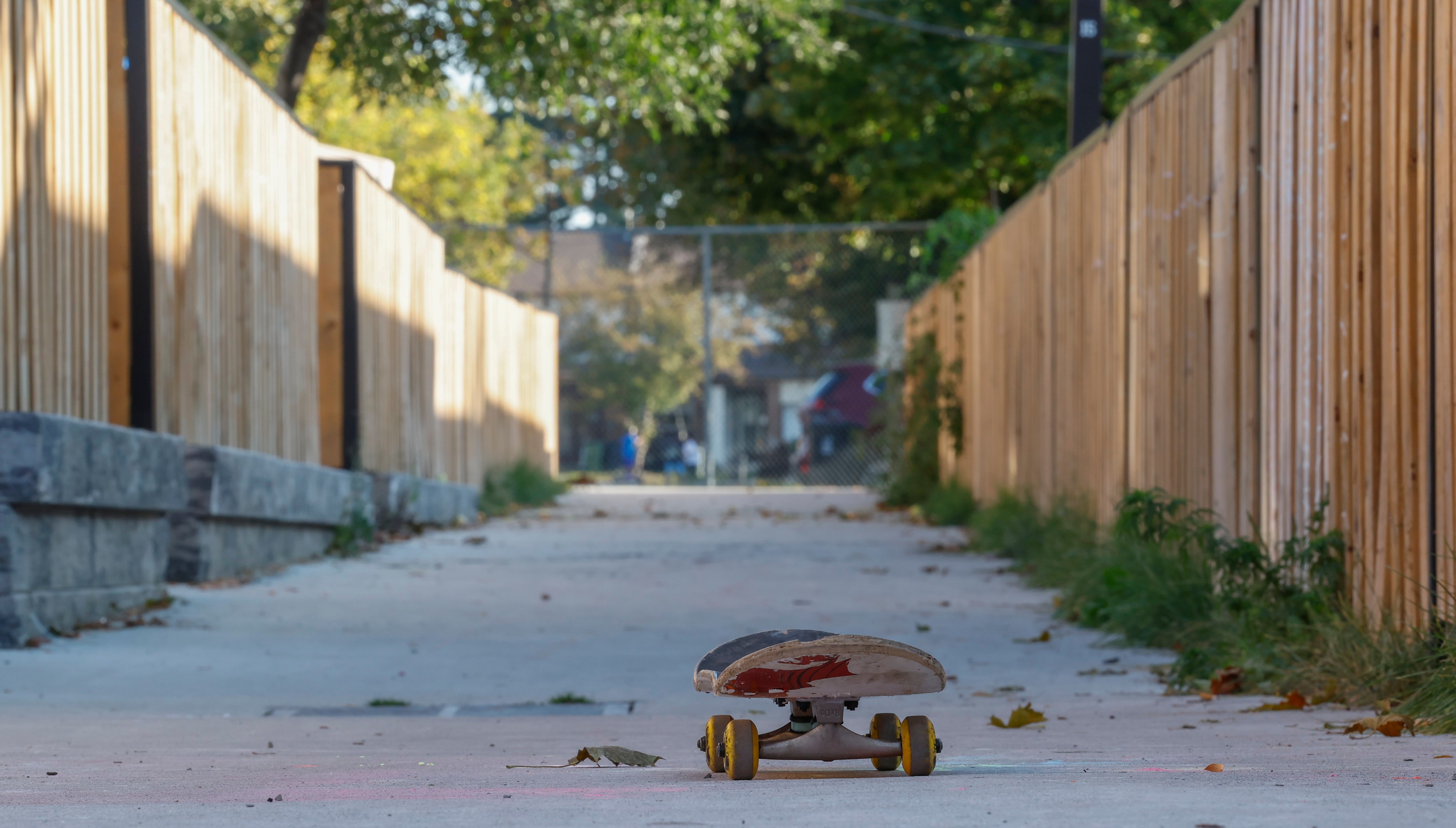 A photo of a skateboard sitting in a laneway