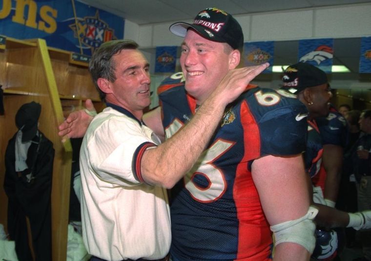 Former Denver Broncos center Tom Nalen hugs his wife during a ceremony  where Nalen was inducted into the Denver Broncos Ring of Fame at an NFL  football game between the Denver Broncos