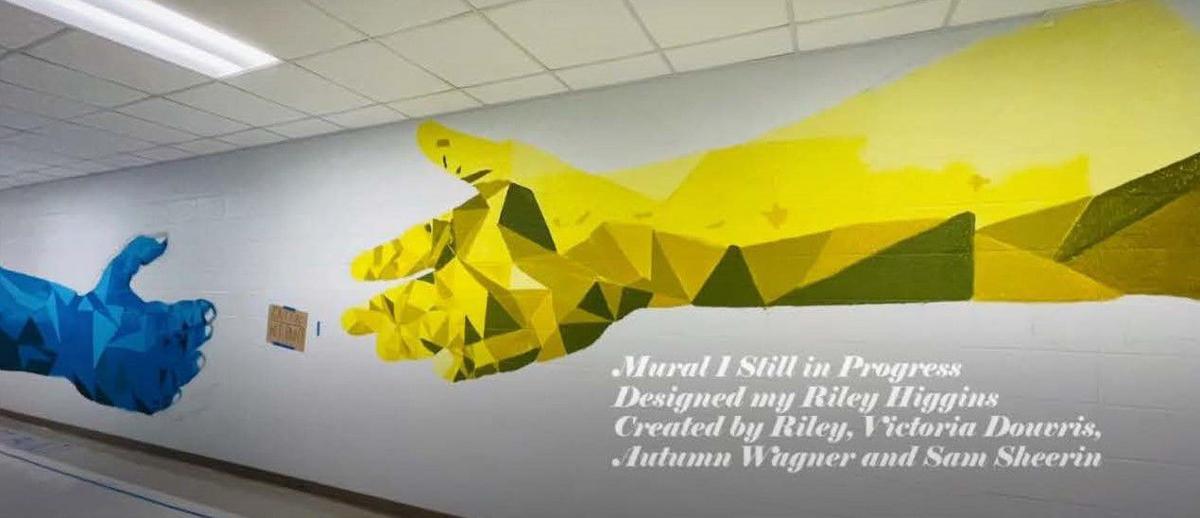 Art students painting high school hall walls with memorable murals