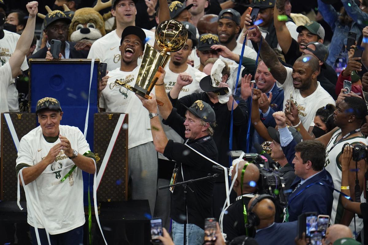 Milwaukee Bucks co-owner Marc Lasry holds up the championship trophy after  they defeated the Phoenix Suns in Game 6 of basketball's NBA Finals in  Milwaukee, Tuesday, July 20, 2021. (AP Photo/Paul Sancya
