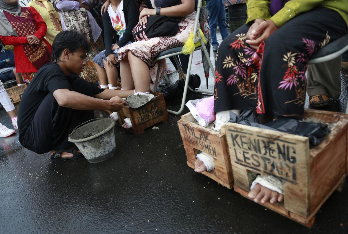 Photos: Indonesian farmers cement feet to protest factory