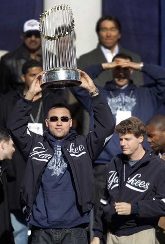 Derek Jeter of the New York Yankees holds up the trophy as he